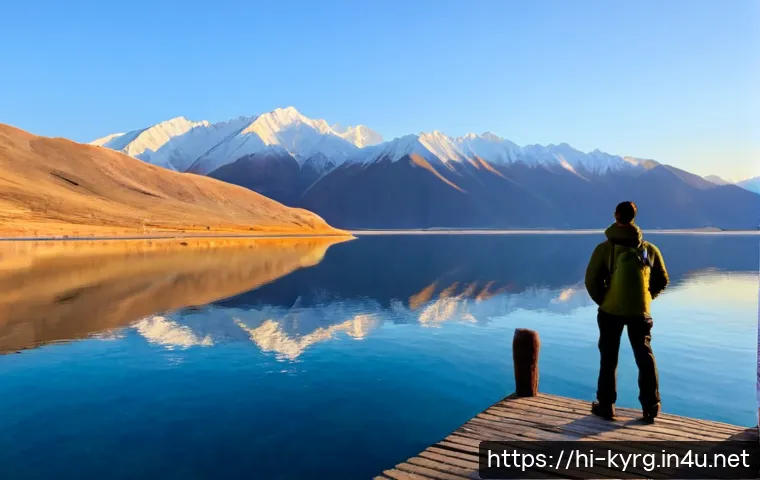 이식쿨 호수 여행 - Photorealistic sunrise view of Issyk-Kul Lake in Kyrgyzstan, calm deep-blue water reflecting snow-ca...
